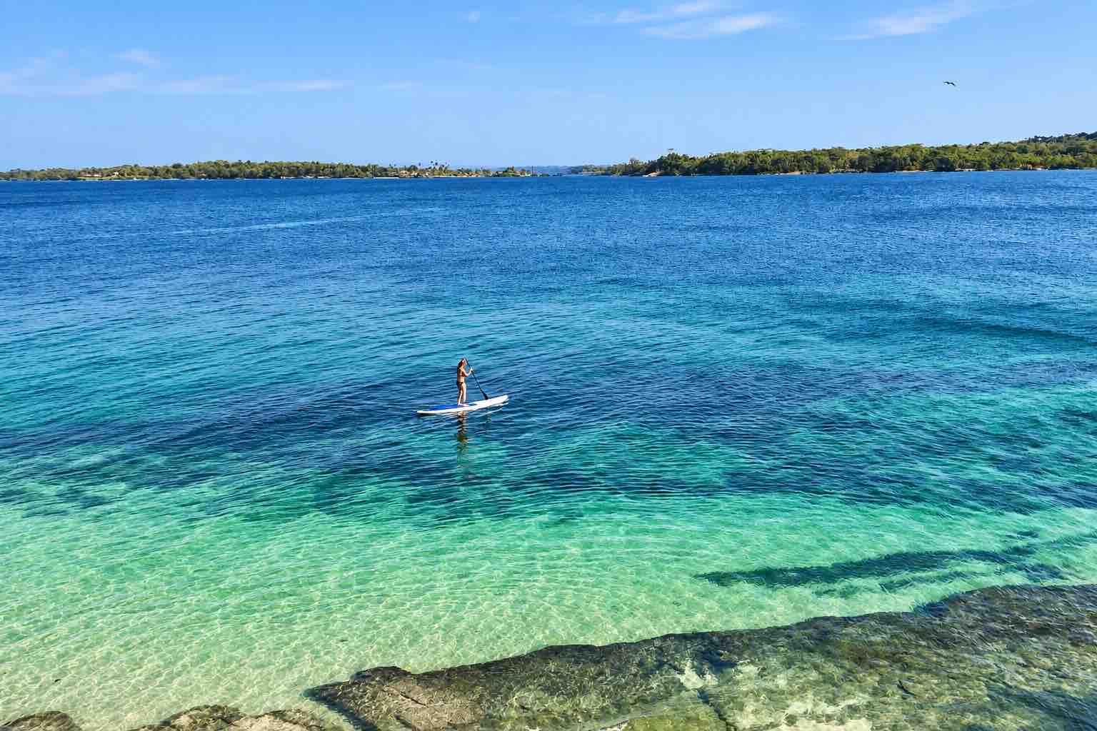 Guest paddleboarding over clear water during a Pearl Islands Panama Day Trip