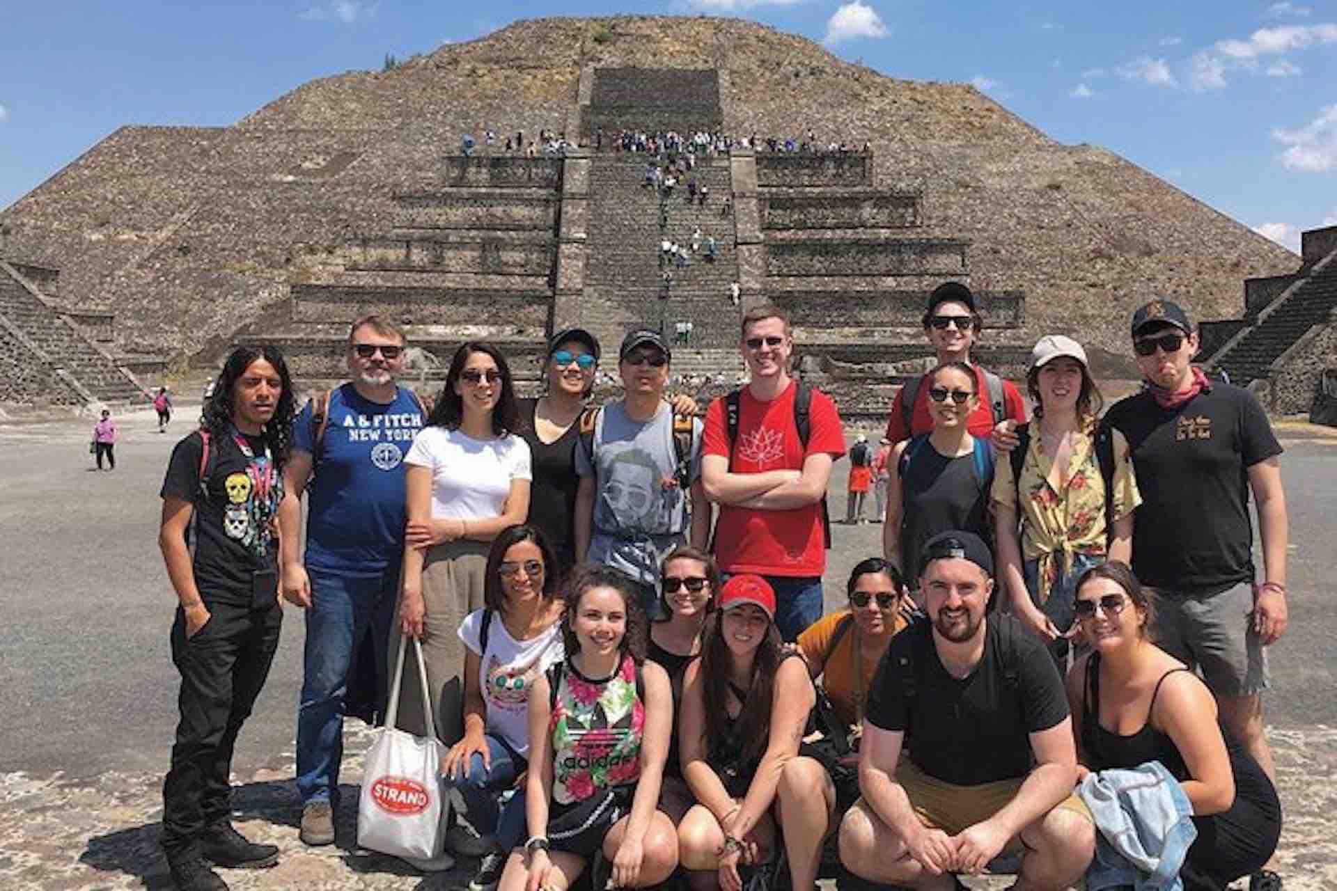 Foto de grupo de visitantes de las pirámides de Teotihuacán frente a la pirámide del Sol durante el recorrido