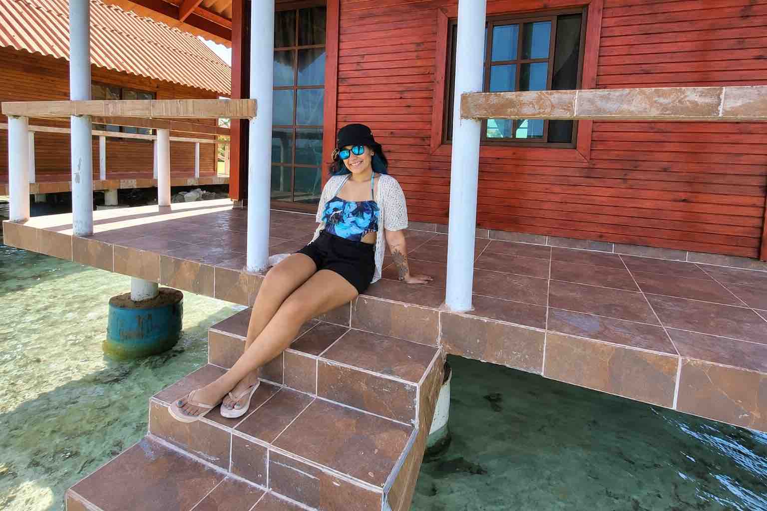 Guest relaxing outside an Isla Guasirdup overwater cabin