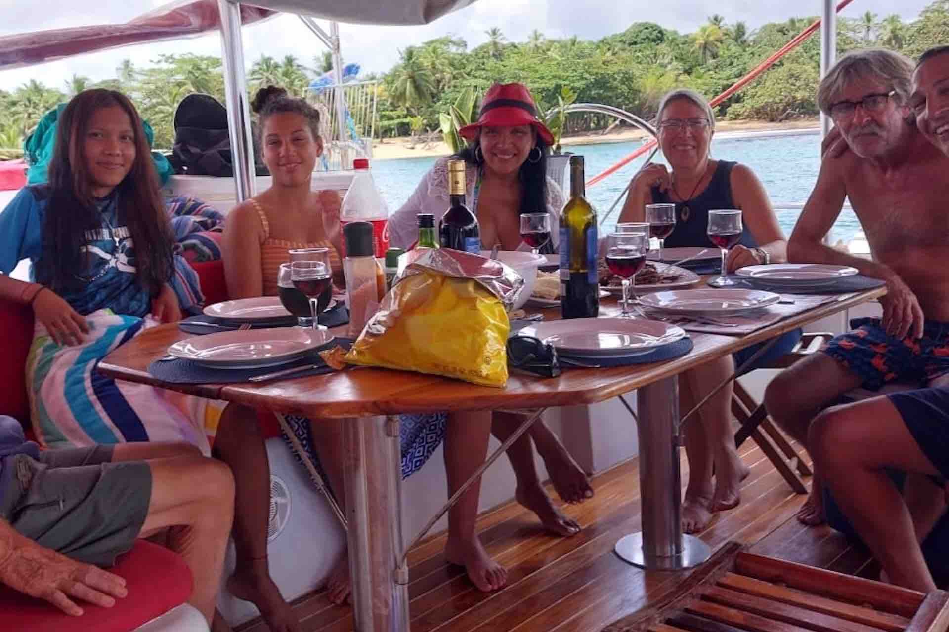 sail San Blas islands catamaran charter guests sitting on table