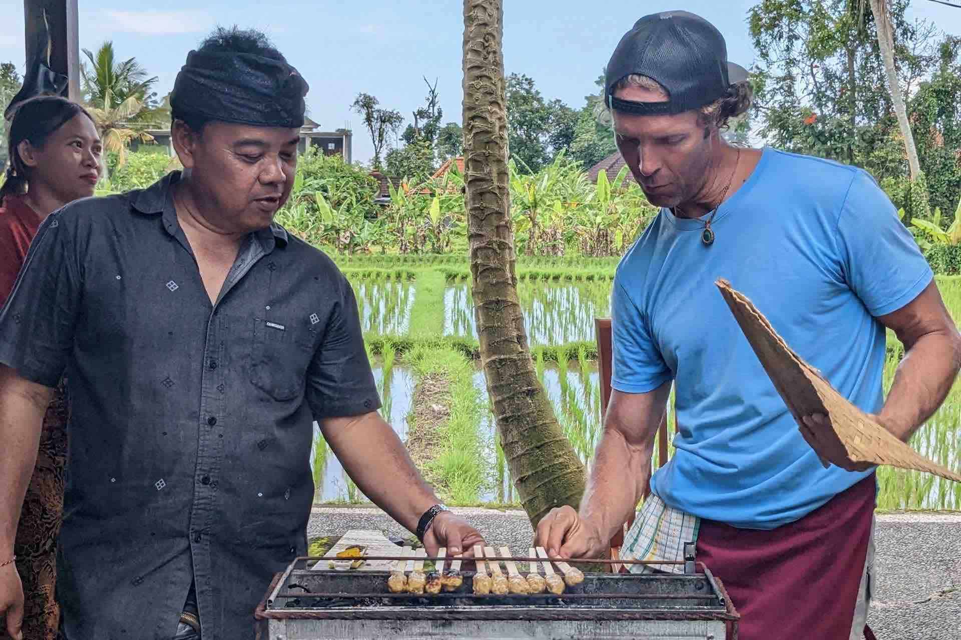 Bali cooking class guest learning BBQ satay