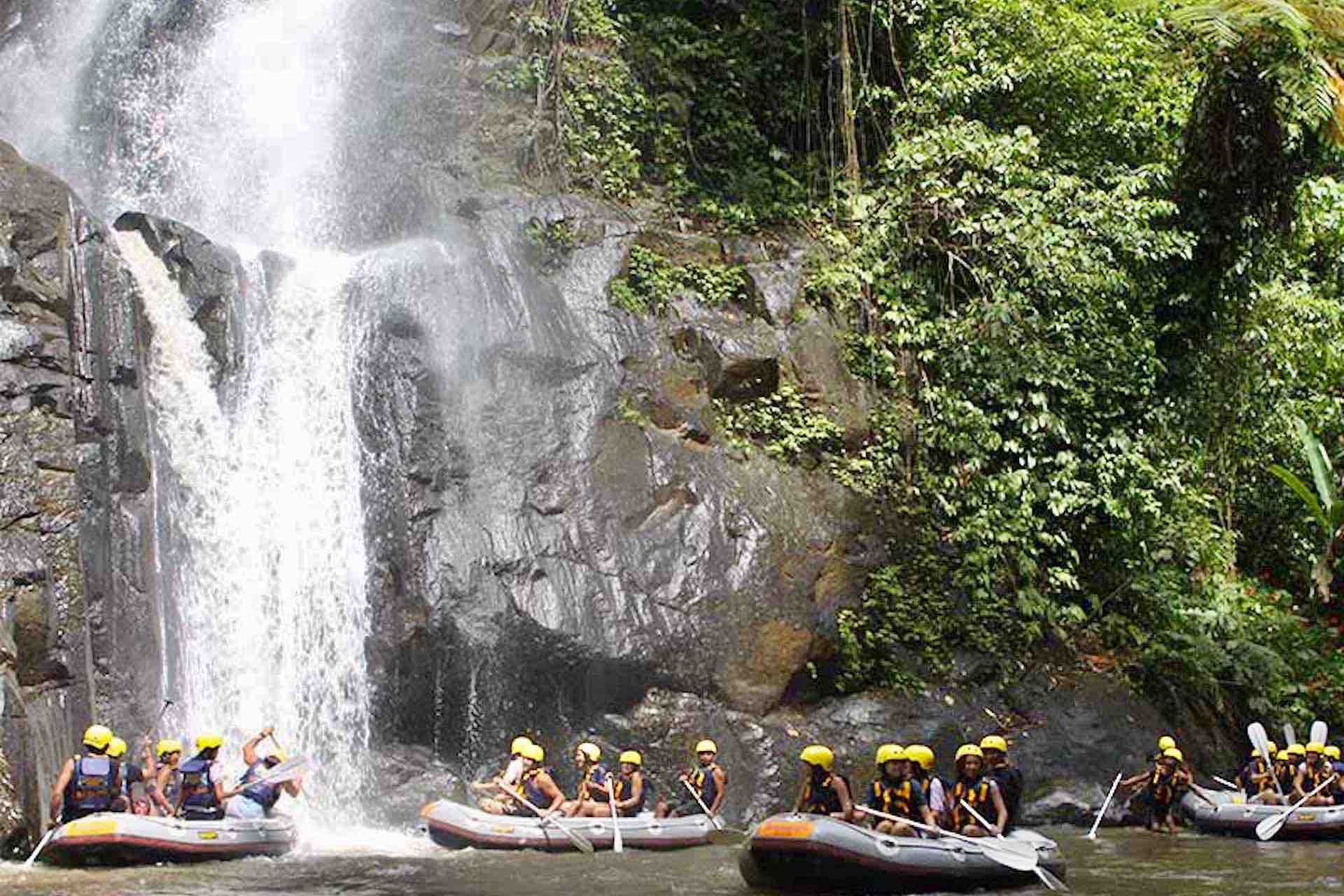 Bali river rafting guests under waterfall