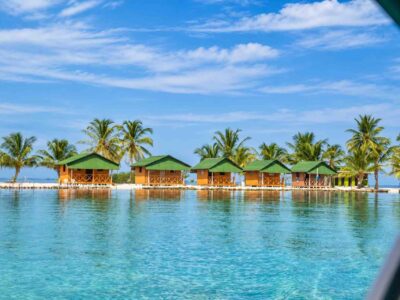 Row of private Isla Miryadup San Blas cabins seen across calm Caribbean water