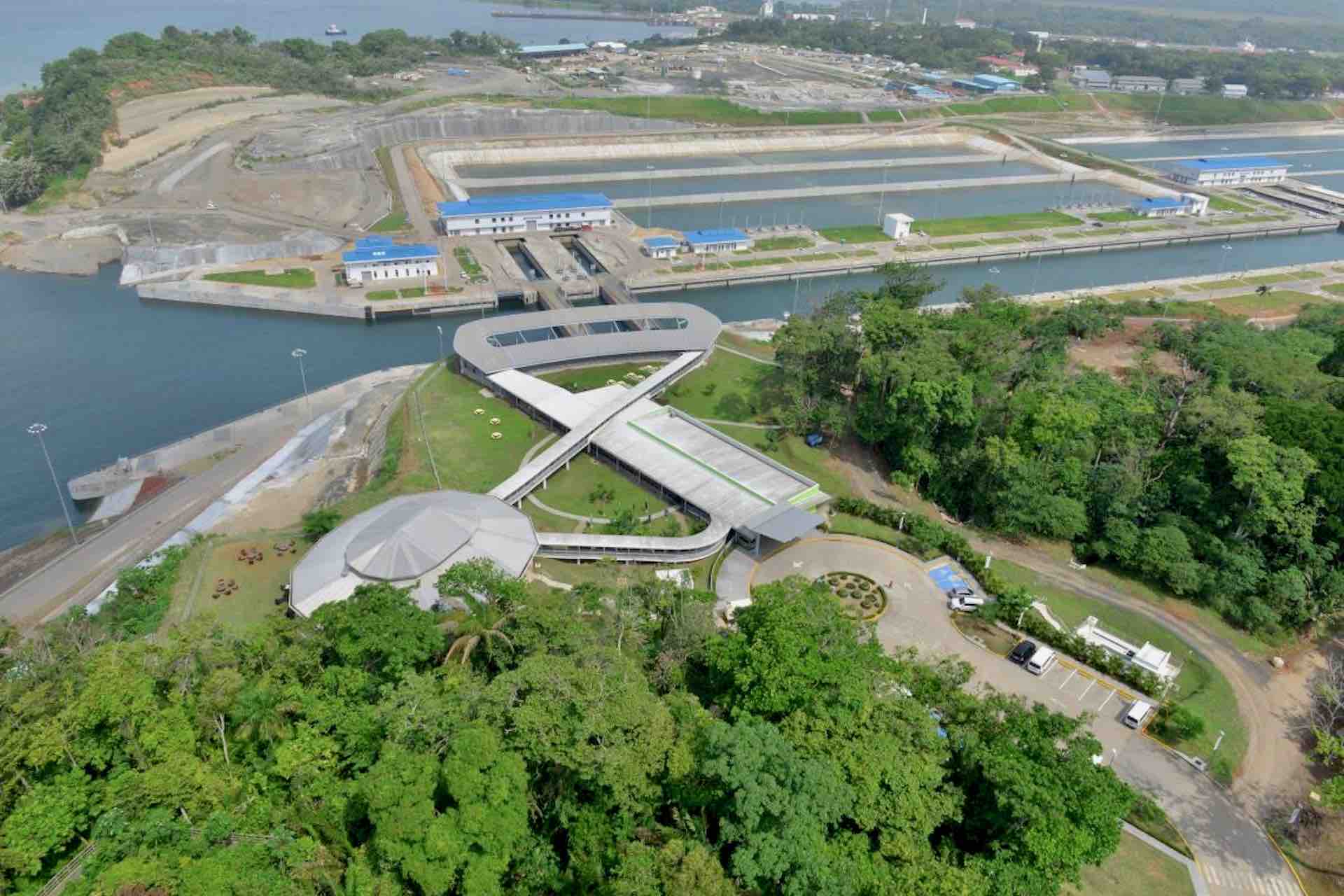 Aerial view of the Agua Clara Visitor Center, surrounding greenery, and canal infrastructure on the Ocean to Ocean Panama Canal Tour
