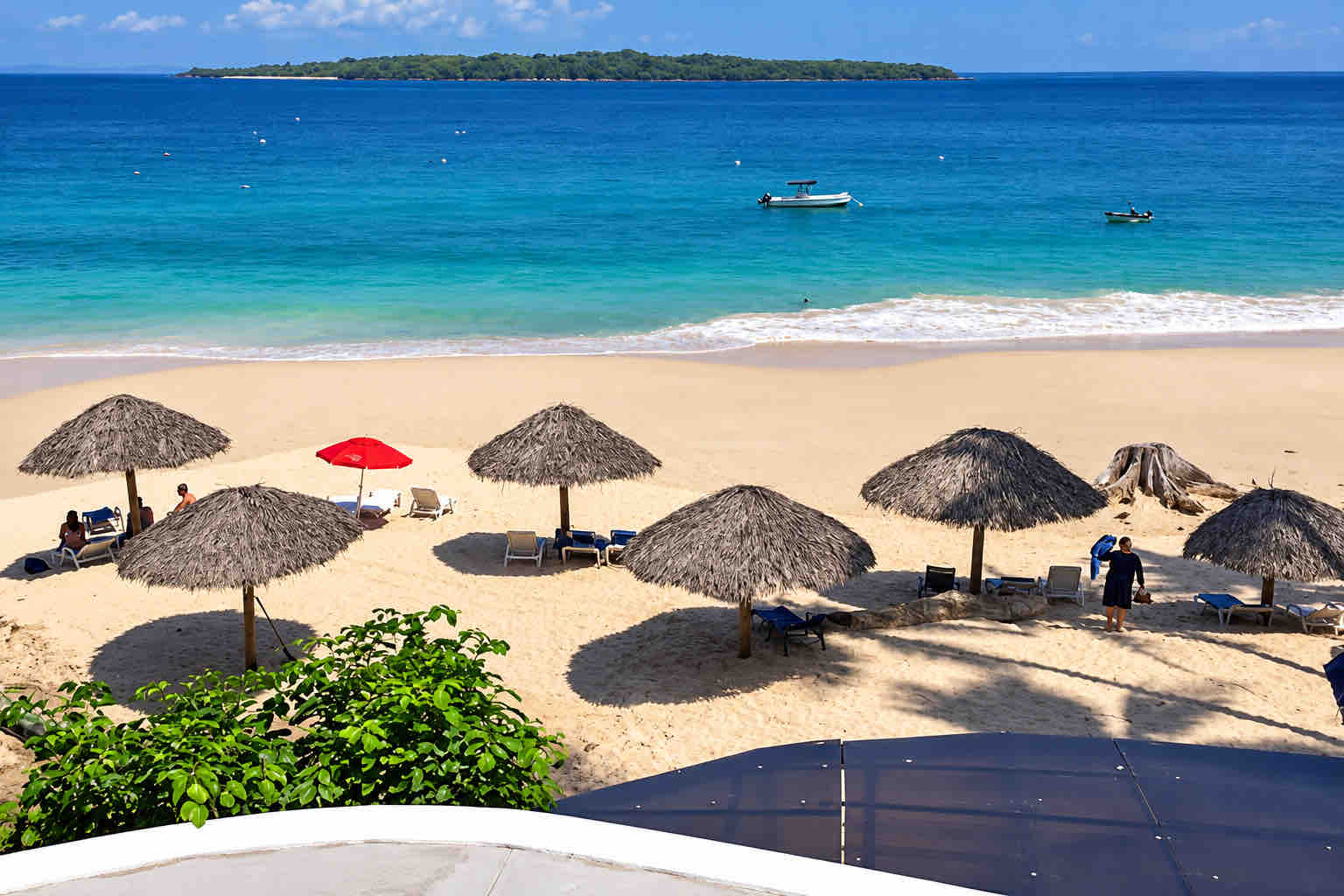 Thatched beach umbrellas and ocean viewed across a white balustrade at Mar y Oro Contadora