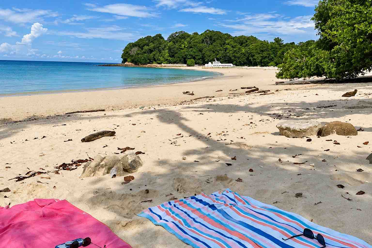 Pimienta y Sal – Pink and striped beach towels in the shade beside Playa Larga