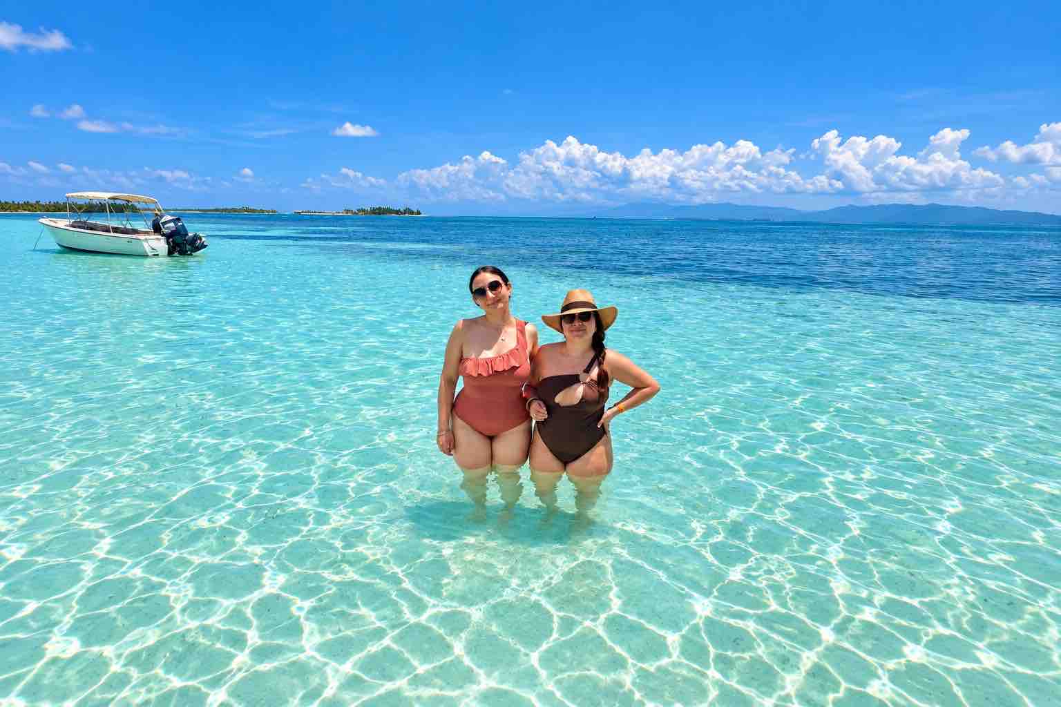 Two guests standing in clear turquoise water at the San Blas Natural Pool