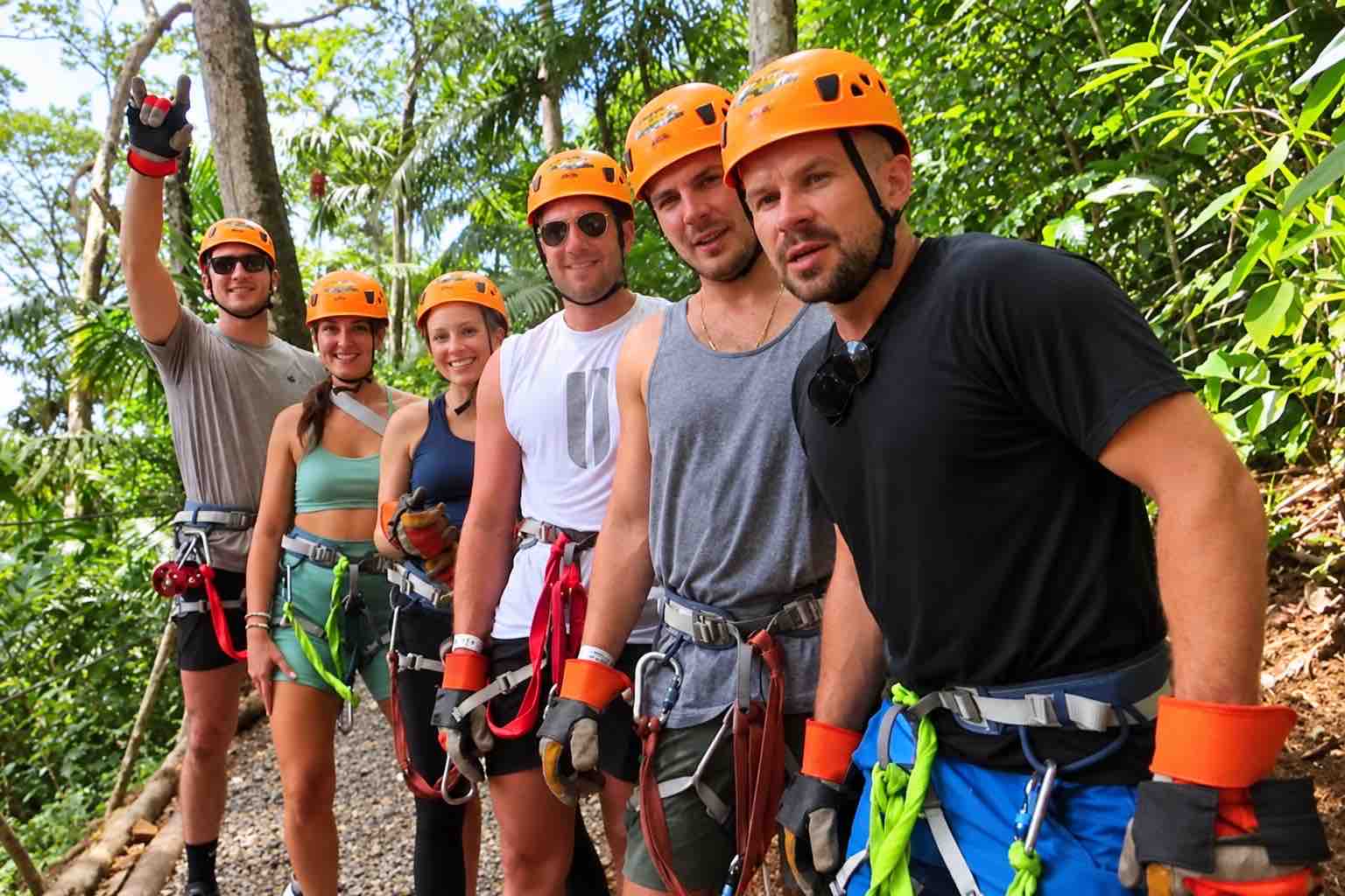Six friends wearing orange helmets and harnesses during Zipline Panama in Gamboa.