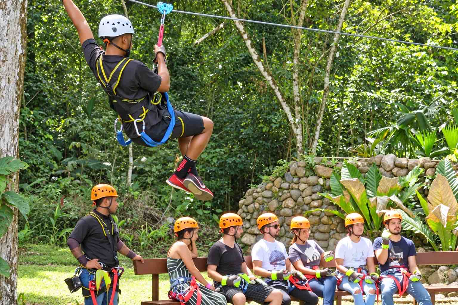 Instructor demonstrating zipline technique to helmeted guests during the Zipline Panama briefing