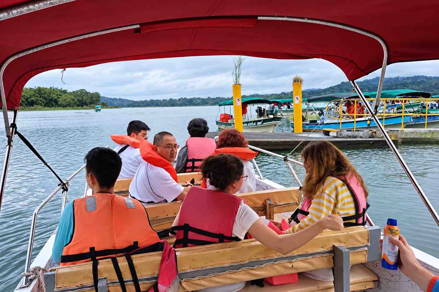 Guests wearing life jackets aboard a boat beside the dock on a Colon Cruise Port Monkey Island and Sloth Sanctuary tour.