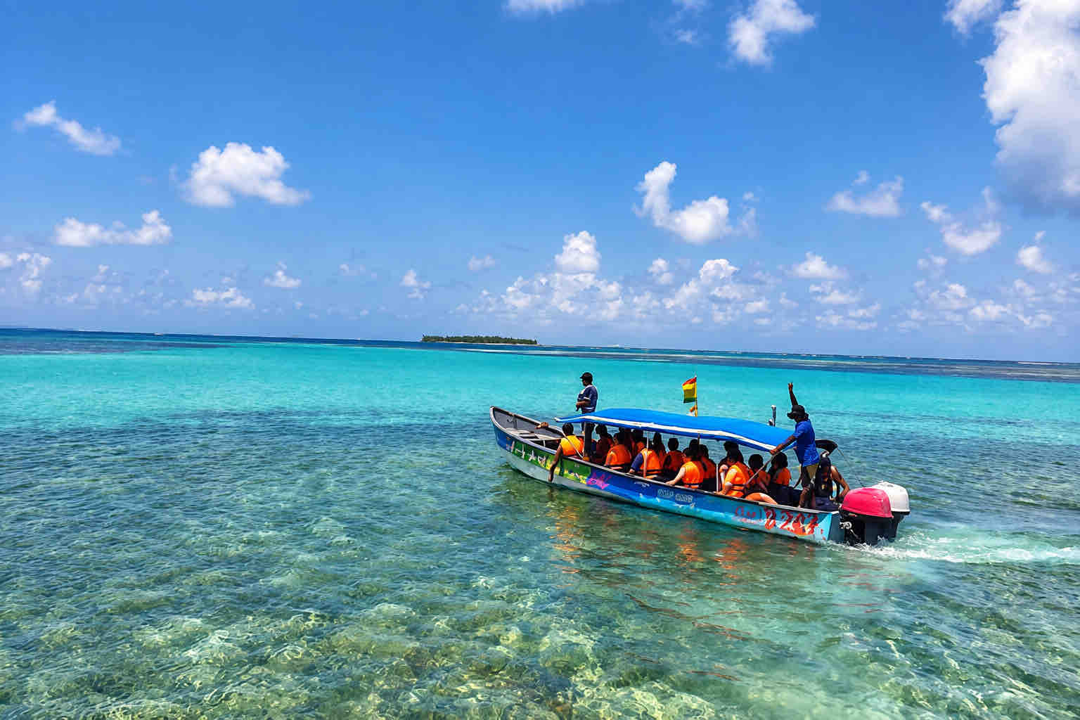 Tour guests riding in a small boat across clear San Blas water