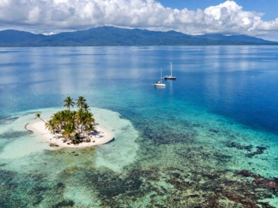 Holandeses San Blas — Tiny Island Sailboats Aerial view of a small palm-covered Holandeses islet with two anchored sailboats.